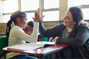 Student and teacher high-fiving